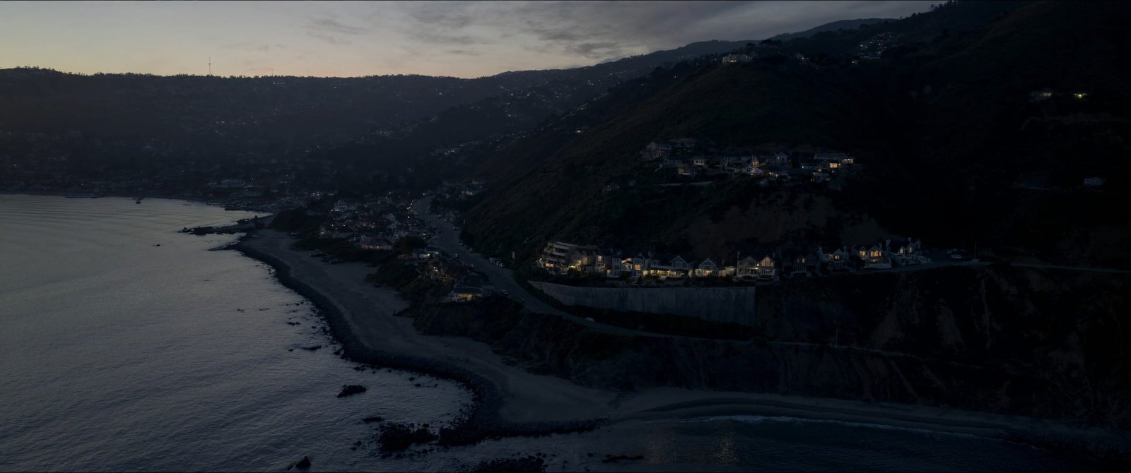 Aerial view of Pacific Coast Highway and cliffside homes at dusk in Southern California